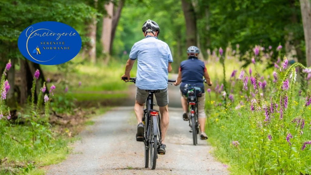 7 façons puissantes dont la conciergerie dynamise l'économie locale 4 Deux personnes à vélo sur un chemin forestier en Normandie, illustrant un séjour écoresponsable soutenu par une conciergerie